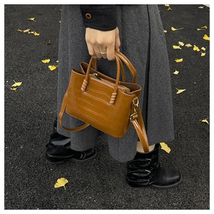 Détail du sac fourre-tout marron à motif crocodile avec double poignée et bandoulière