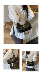 Detail of black quilted shoulder bag with gold chain strap and metallic brand plaque