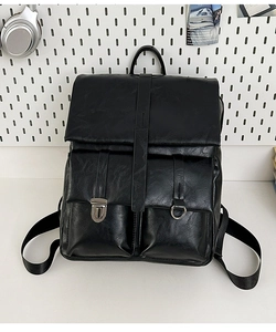 Detail view of black faux leather backpack featuring vintage texture and metal buckle pockets