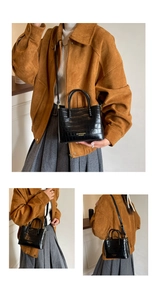 Détail d'un sac cabas noir à motif crocodile montrant les styles de porté et la texture