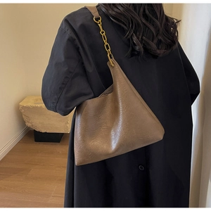 Détail du sac cabas marron foncé montrant le cuir souple et la bandoulière chaîne