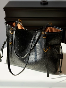 Black ostrich pattern tote bag with gold hardware and slim shoulder strap