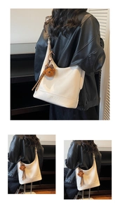 Detailed view of matte white PU leather underarm bag with cute plush bear charm
