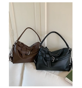 Detail of soft litchi grain leather tote bags in black and brown with metal buckle strap