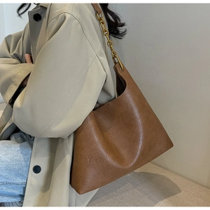 Gros plan sur un sac hobo marron texturé vintage avec bandoulière chaîne dorée