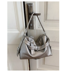 Detailed close-up of metallic silver tote bag with buckle and grain leather texture