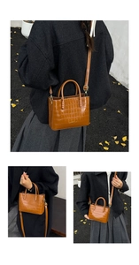 Détail d'un sac cabas marron motif crocodile avec finitions dorées et bandoulière