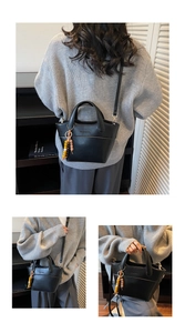 Detail of black PU tote bag with wooden bead charm and detachable shoulder strap
