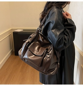 Detailed side view of vintage brown leather tote bag showing pocket and strap texture