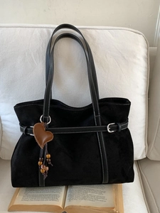 Large black suede tote bag with white stitching and decorative heart pendant for women