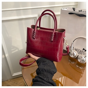 Détail du sac cabas rouge texture crocodile avec zip doré et bandoulière réglable