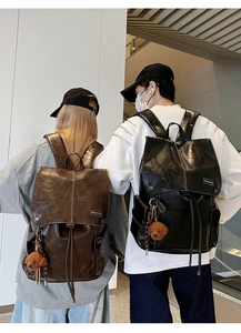 Detail of vintage PU leather backpacks in brown and black with cute teddy bear charms