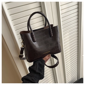 Détail du sac cabas marron foncé en cuir croco avec d'élégantes finitions dorées