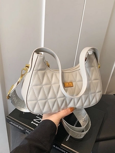 Quilted half-moon shoulder bag in light grey with gold hardware and wide woven strap