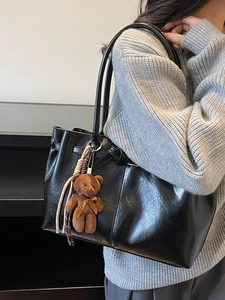 Retro black faux leather tote bag with brown plush bear charm and sleek shoulder straps