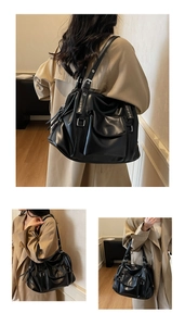 Detail view of black leather tote with adjustable buckle handles and soft pleated texture