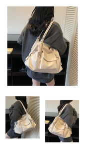 Detail of off-white tote bag showing side pockets and soft leather texture