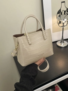Sac fourre-tout beige en cuir avec motif crocodile, poignées rondes et bandoulière amovible