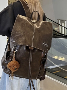 Vintage large capacity brown leather backpack with contrast stitching and plush charm