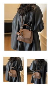 Close-up of litchi texture coffee leather handbag with mini bag charm and tassel