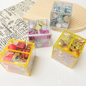 Close-up of four transparent gift boxes with colorful Christmas balls and festive ornaments