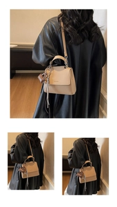 Detail of beige trapezoid handbag with gold hardware and stylish scarf wrap on handle