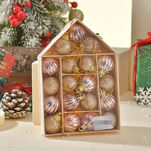 Detail of Christmas ornament set with pink and gold balls in a house-shaped gift box
