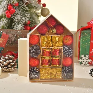 Christmas ornaments set in house-shaped box with red baubles, pine cones, and gold drums