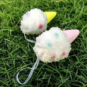 Détail d'ornements de glace de Noël en peluche avec pompons colorés sur l'herbe