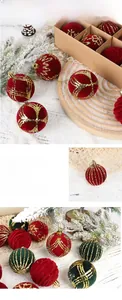 Detail of red and green flocked Christmas balls with gold glitter patterns and hanging ropes