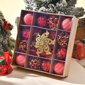 Gros plan d'ornements de Noël rouges et dorés dans une boîte avec décor festif