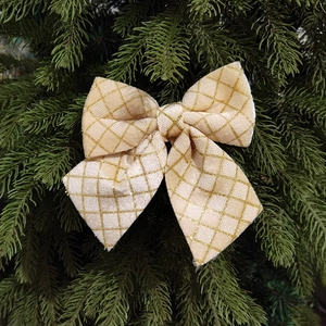 Christmas tree decoration beige ribbon bow with golden glitter diamond pattern on pine needles