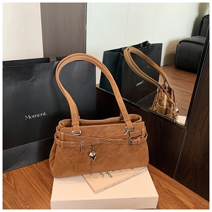 Detailansicht der braunen Vintage-Schultertasche mit Stern-Anhänger und Metallteilen