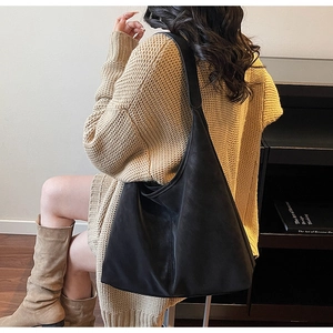 Side view of large black Hobo tote bag showing capacity and drape on a model's shoulder