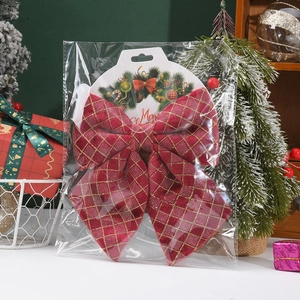 Detailed view of red Christmas bow with gold glitter grid in festive tree packaging