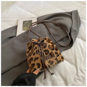 Detail of leopard print plush bucket bag with brown faux leather drawstring and bow