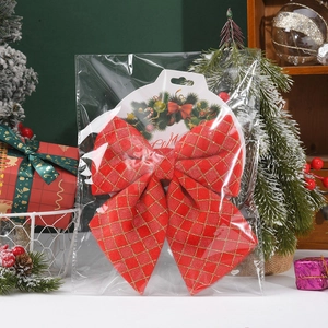 Macro shot of large red Christmas bow with gold glitter grid in festive clear packaging