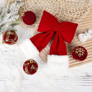Macro detail of red velvet Christmas bow with faux fur trim on a festive wooden tray