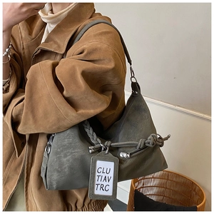 Détail du sac à bandoulière gris avec éléments tissés et texture cuir vintage
