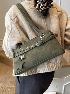 Schultertasche in olivgrün mit Herz-Anhänger, präsentiert an einer Damen-Schulter