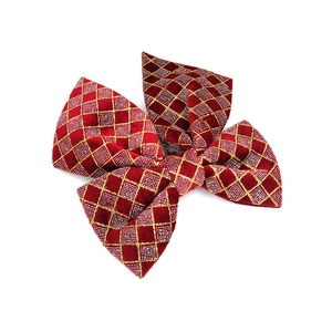 Close-up of red velvet Christmas bow featuring glittery gold diamond patterns for tree decor