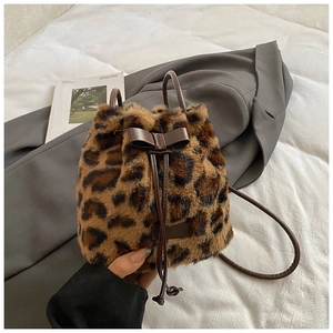 Detail of plush leopard print bucket bag with brown bow knot and drawstring closure