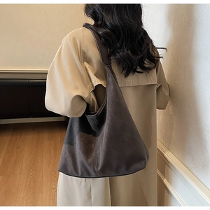 Detail view of large dark brown suede tote bag featuring wide shoulder straps and soft texture