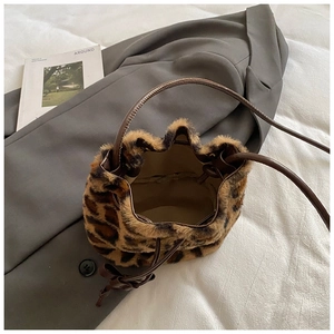 Detail view of leopard print plush bucket bag with leather drawstring and inner capacity