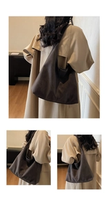 Detail of a large brown suede hobo tote bag worn with a beige trench coat on shoulder