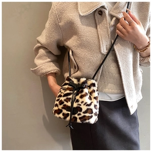 Detail of leopard print faux fur bucket bag with black drawstring and bow detail