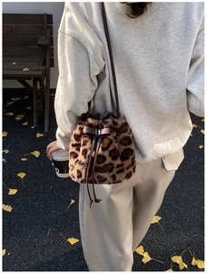 Detail of leopard print faux fur bucket bag with leather drawstring and bow detail
