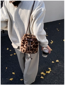 Detail of leopard print plush bucket bag with ribbon bow and drawstring closure