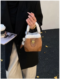 Vue détaillée du mini sac seau en daim marron avec bordure en fausse fourrure et fermoir doré
