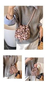 Detail of pink leopard faux fur bucket bag featuring a soft drawstring and bow accent